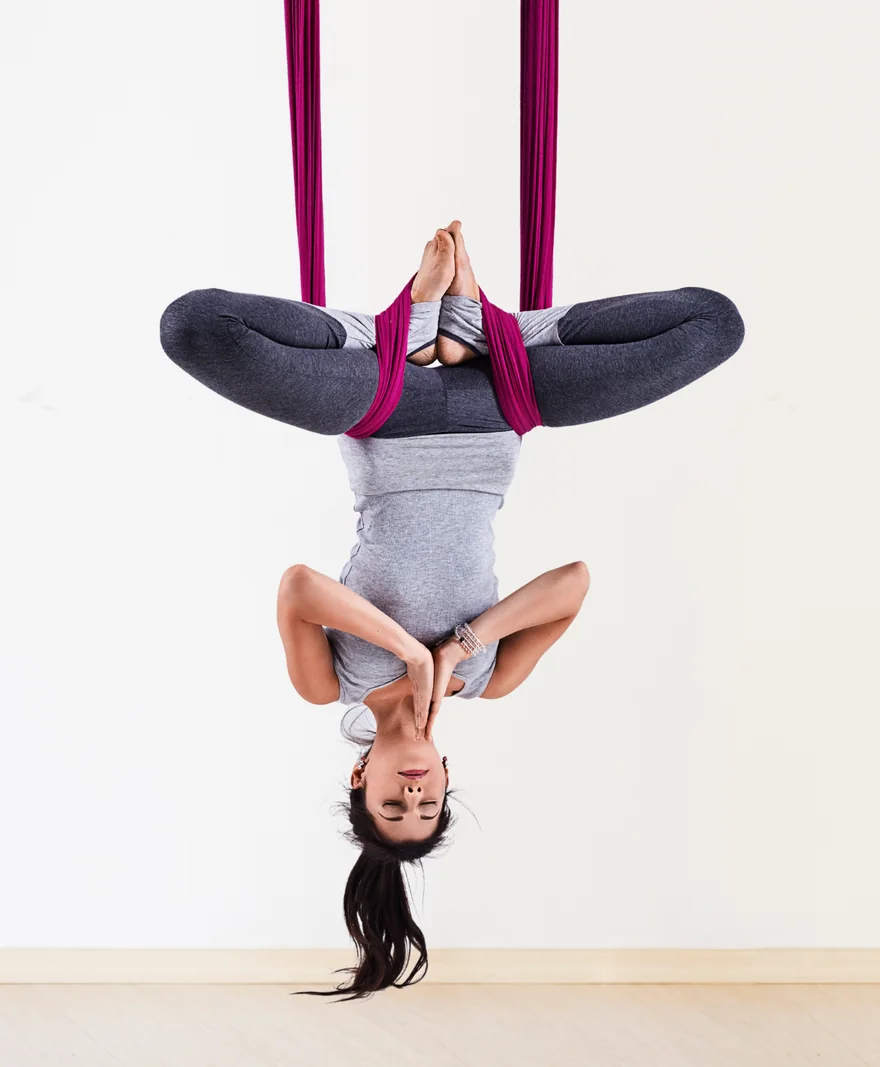 Allieva a testa in giù nel trapezio aereo durante il Totalbody Workout Aereo